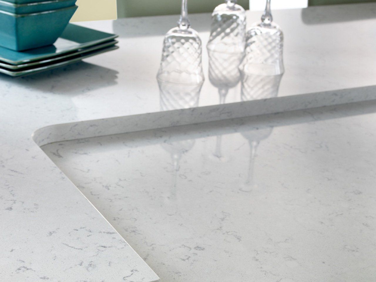 A white counter top with three wine glasses on it