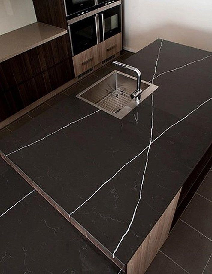 A kitchen with a black counter top and a sink
