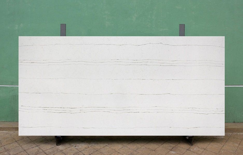 A large white tile is sitting on a stand in front of a green wall.