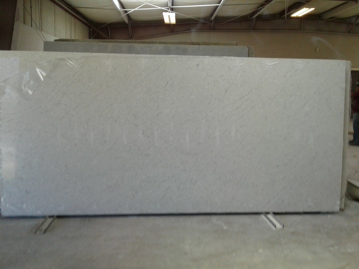A large white slab of granite is sitting on top of a concrete floor in a room.
