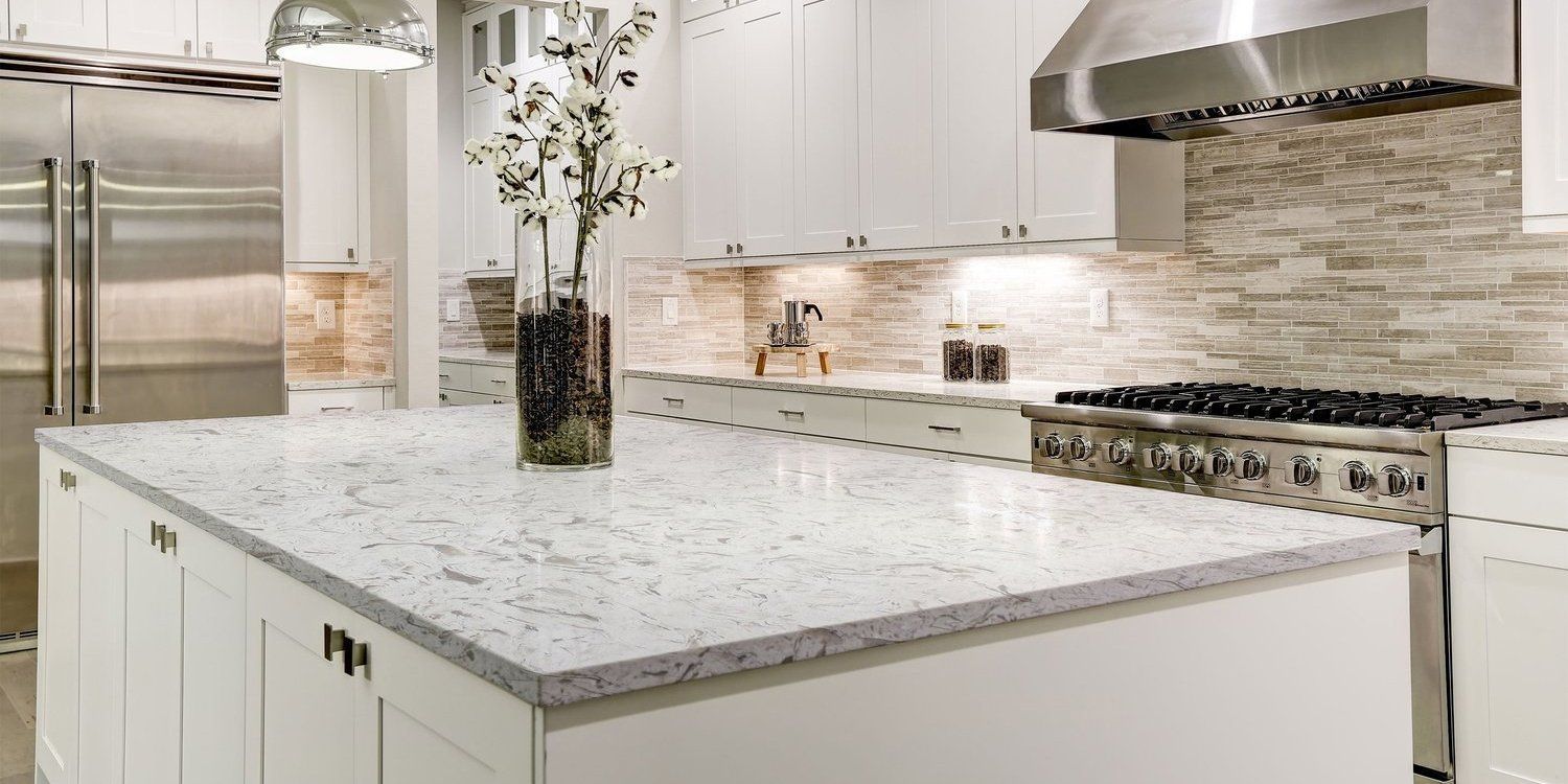 A kitchen with white cabinets , granite counter tops , stainless steel appliances and a large island.