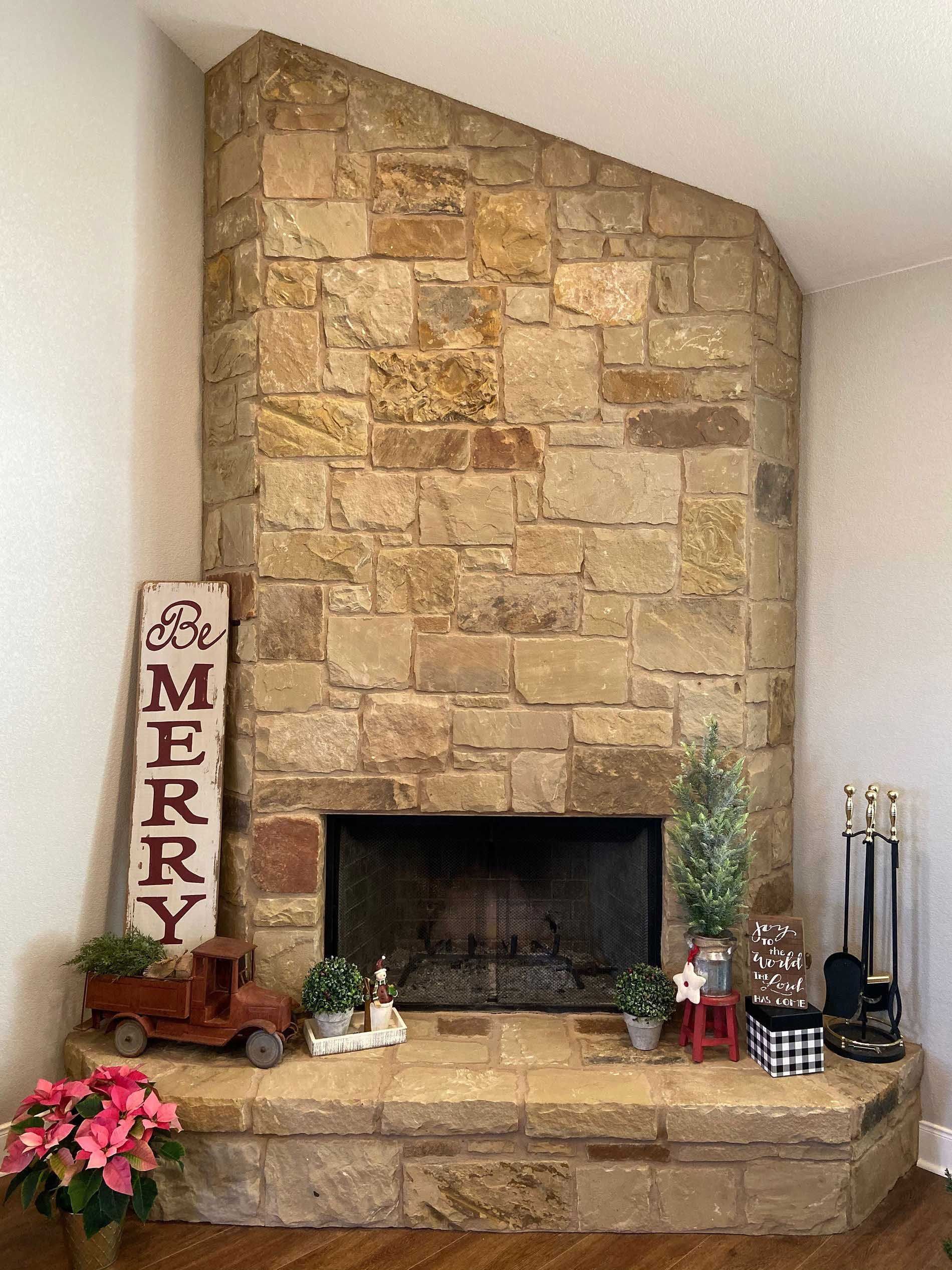 Stone fireplace with Christmas decorations, including a 