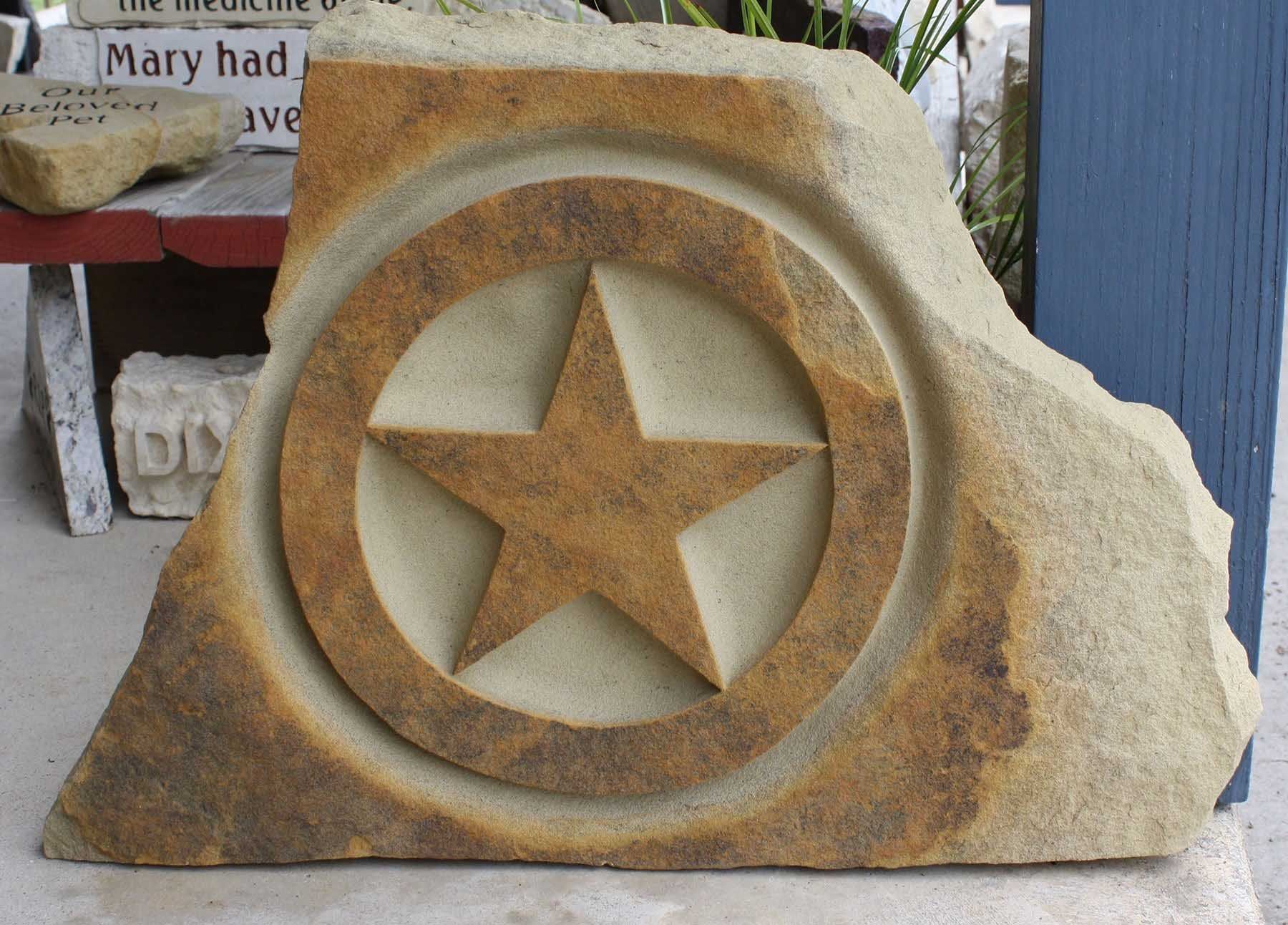 Stone carving of a star within a circle, set into a rough-edged sandstone block.
