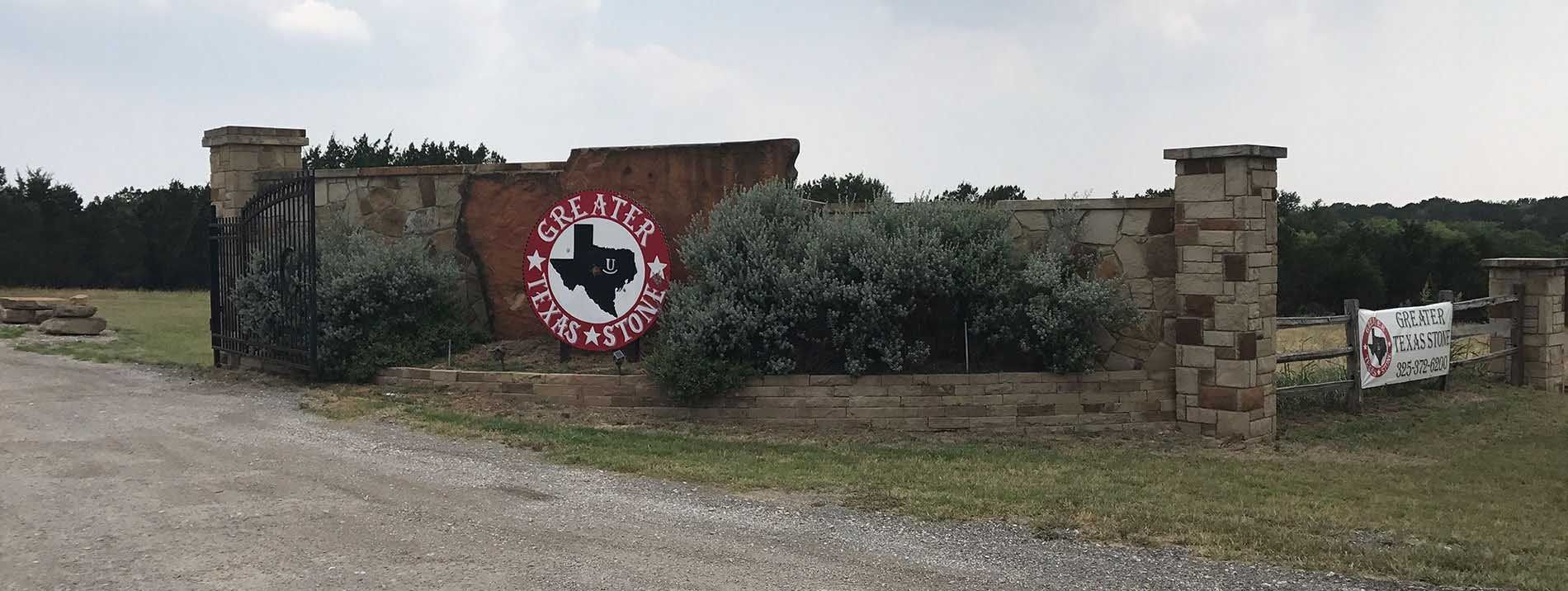 Entrance gate with a Texas flag logo inside a white and red circle.