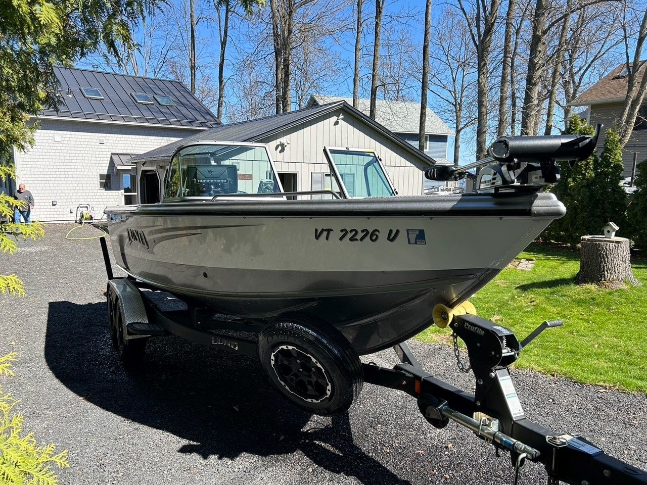 Boat on a trailer in front of a house, with Vermont registration.