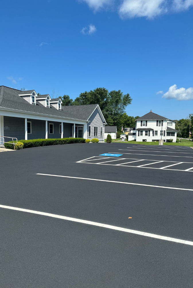 A parking lot in front of a house on a sunny day