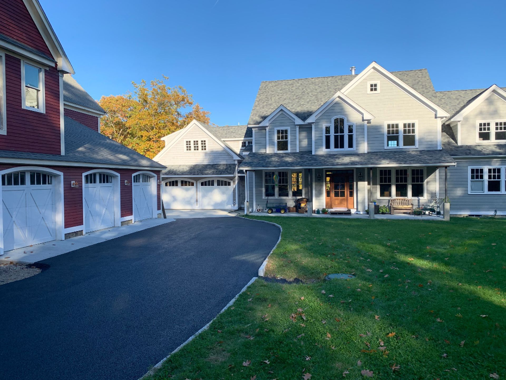 A large house with a lot of garage doors and a driveway leading to it.