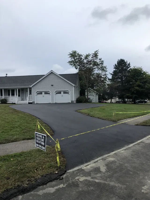 A driveway is being paved in front of a house.
