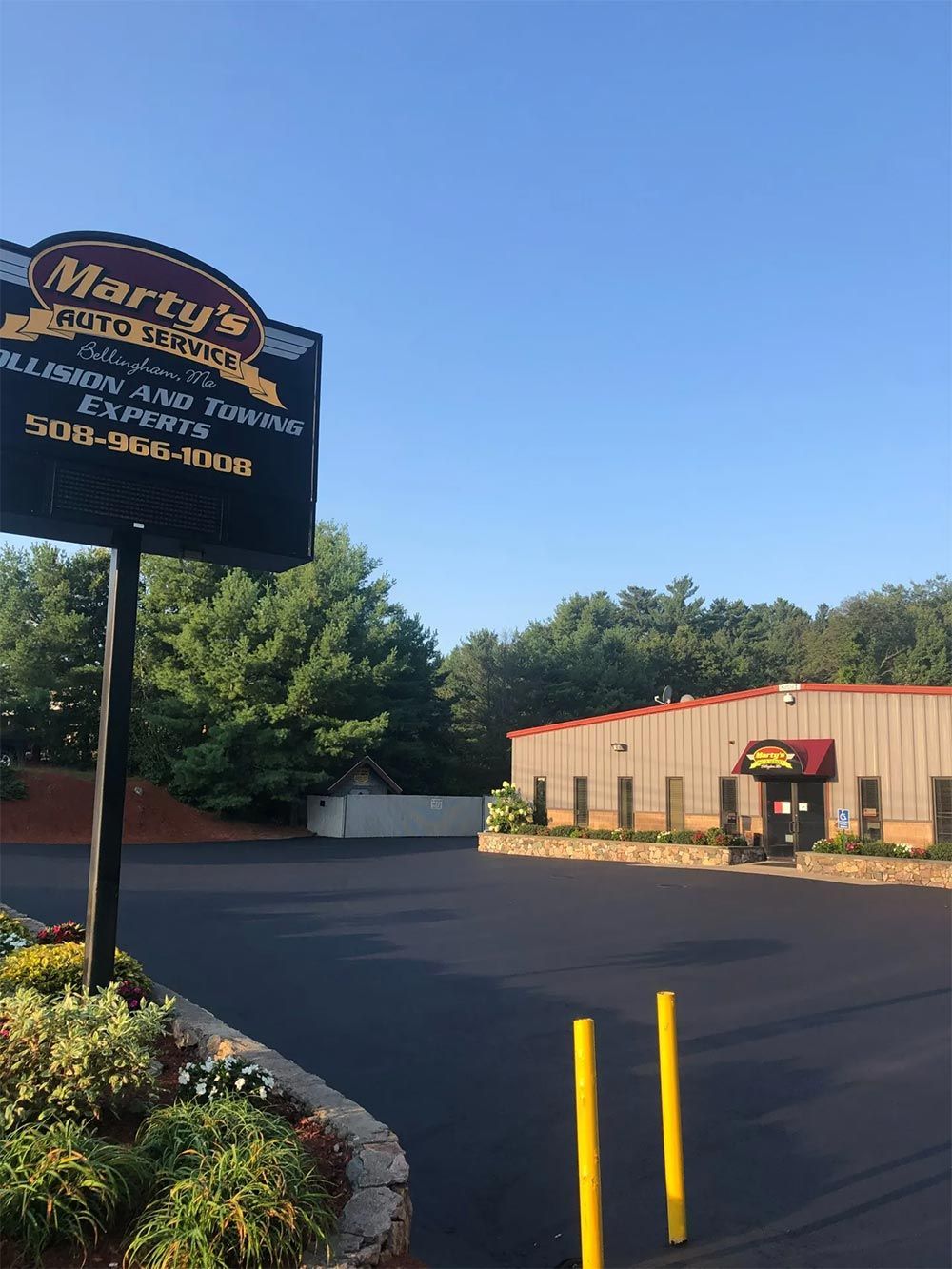 A large black sign is sitting in front of a building.
