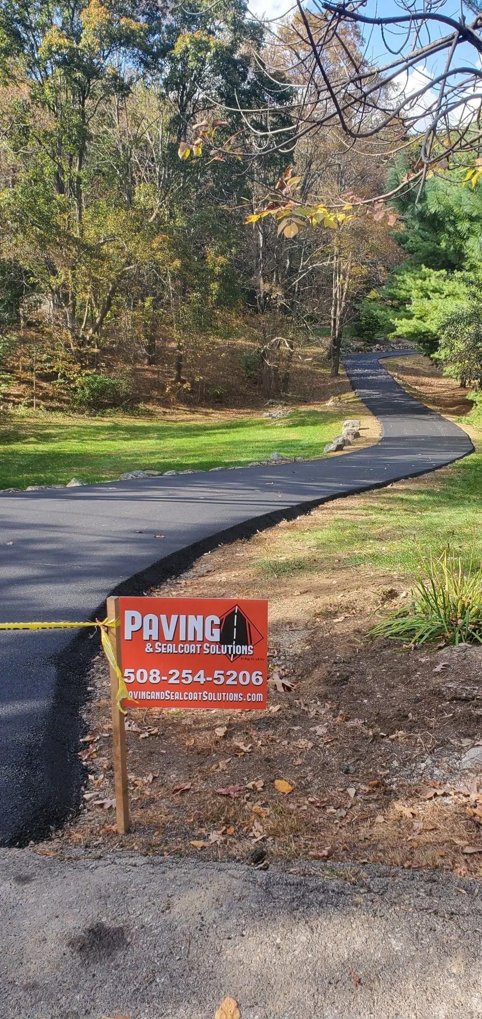 There is a sign on the side of the road that says paving.