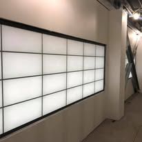 Large rectangular window with grid pattern and diffused lighting. White walls and a column.