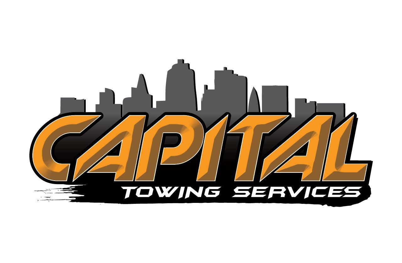 A logo for capital towing services with a city skyline in the background