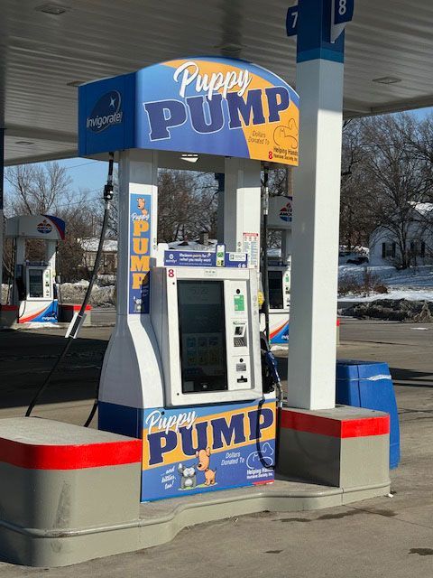 A gas pump with a sign that says puppy pump on it