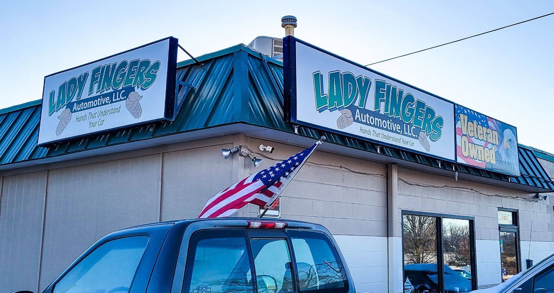 A truck is parked in front of a lady fingers automotive store