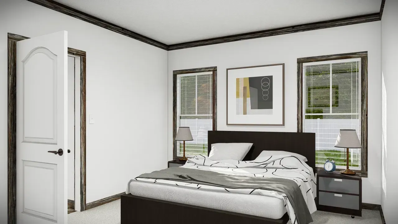 Bedroom interior with a bed, windows, artwork, and a partially open door. White walls and dark brown trim.