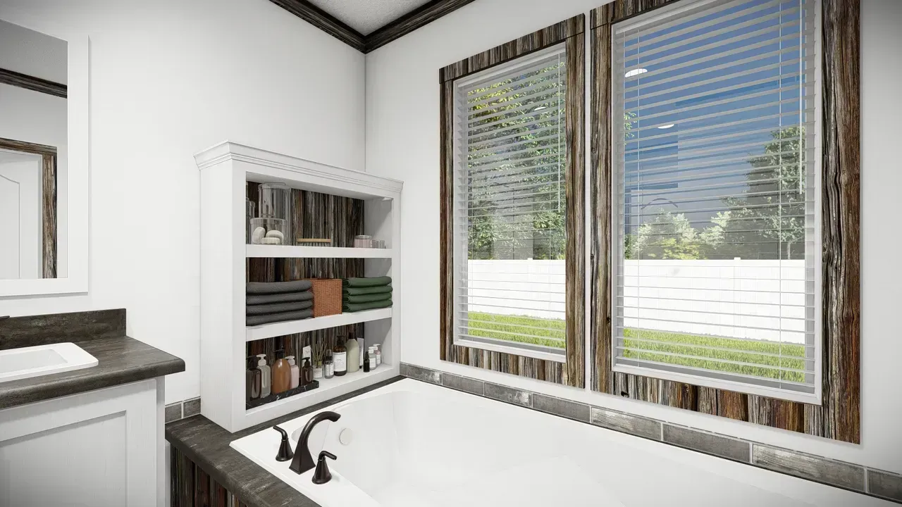 Bathroom with a white bathtub, shelving unit, and windows with a view of a grassy yard.