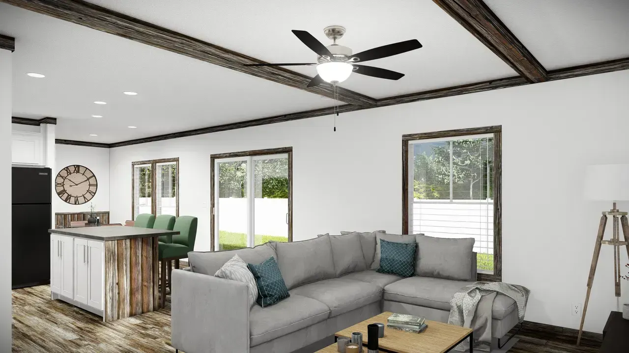 A modern living space with a gray sectional sofa, wooden beams, and a kitchen island.