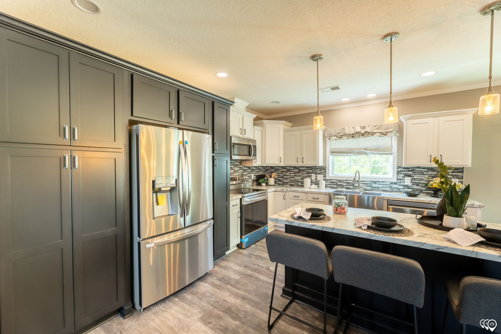 A kitchen with stainless steel appliances and gray cabinets.
