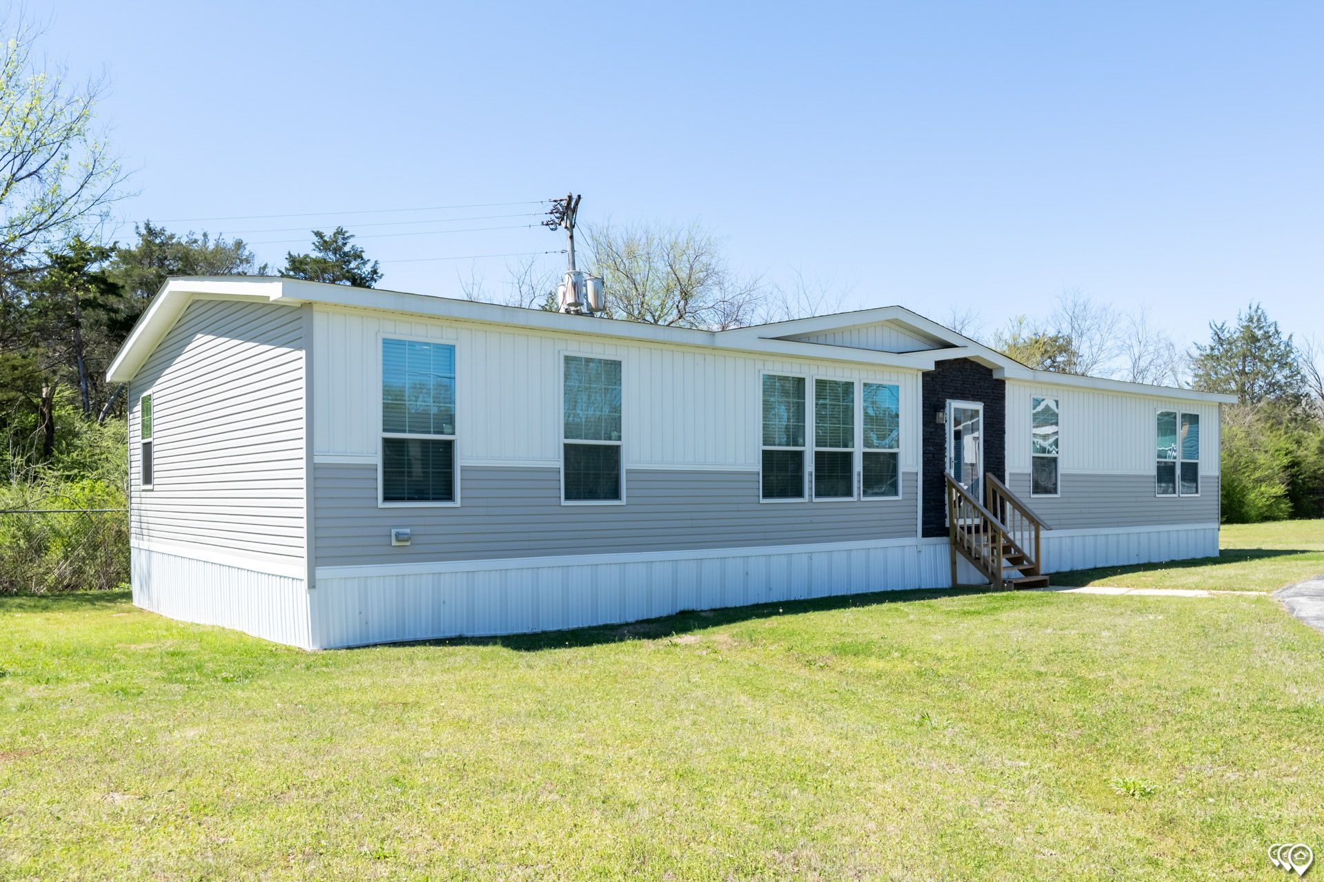 A mobile home is sitting on top of a lush green field.