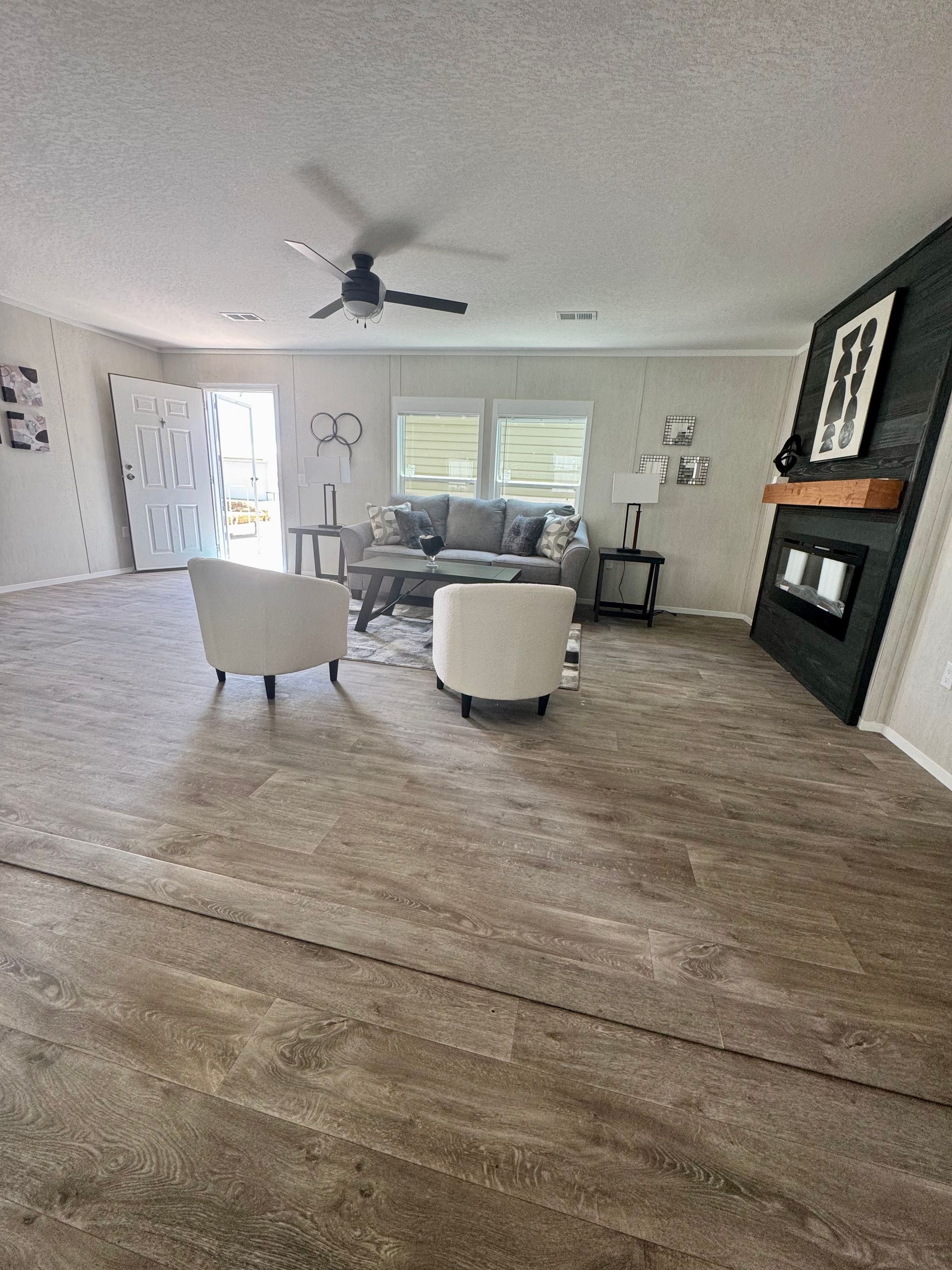 A living room with a couch, chairs, and a fireplace.