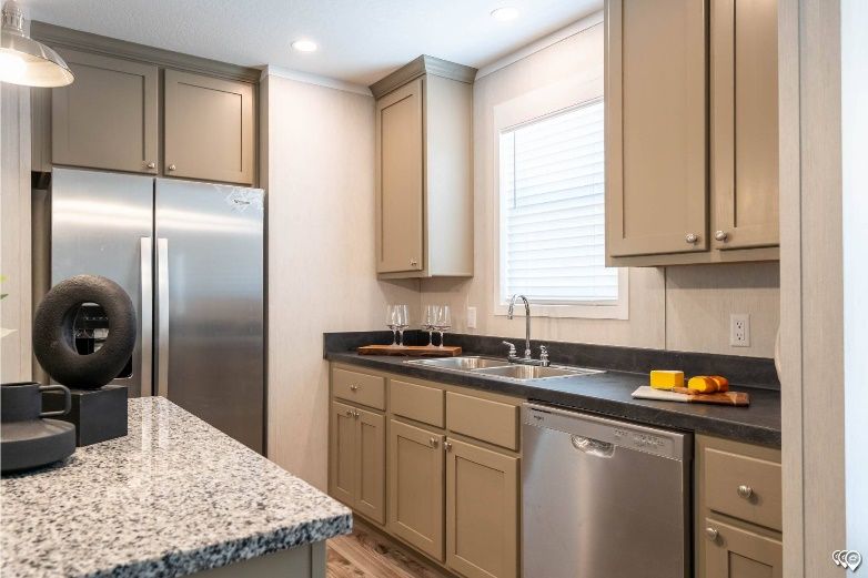 A modern kitchen with stainless steel appliances, gray cabinets, and a granite countertop.