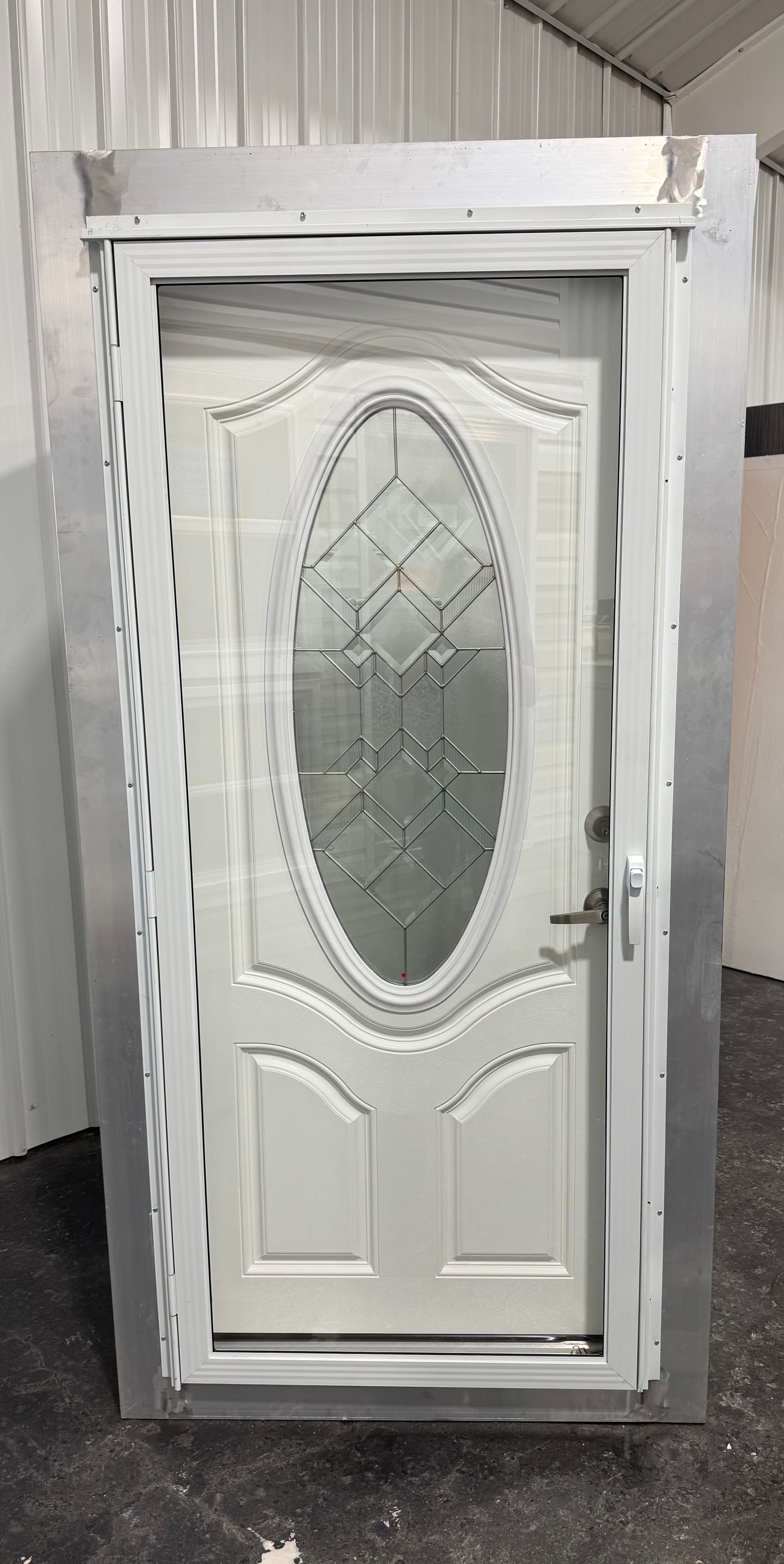 A white door with a glass window is sitting in a room.