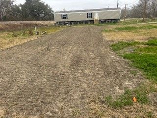 A stretch of land leading up to a mobile home.