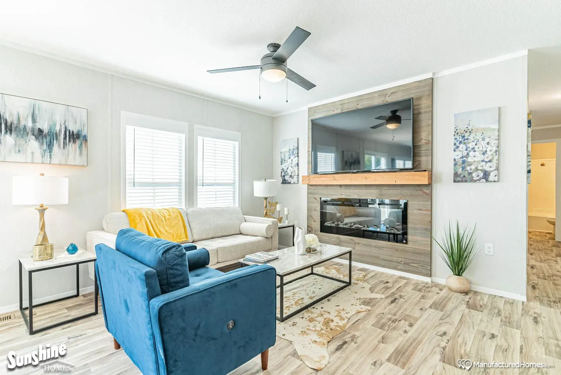 A living room with a couch, chair, coffee table, fireplace and television