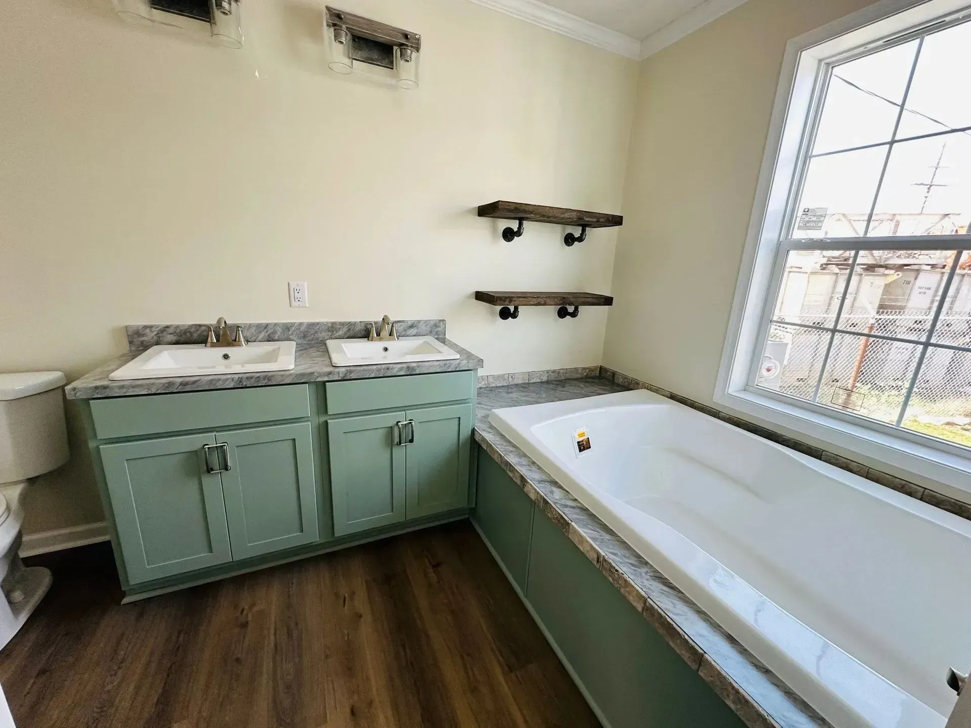 A bathroom with two sinks, a tub and a window