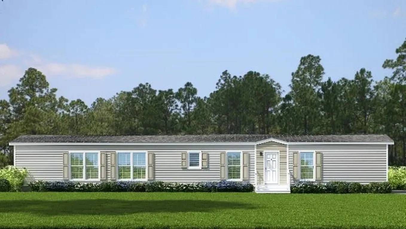 A large mobile home is sitting on top of a lush green field.