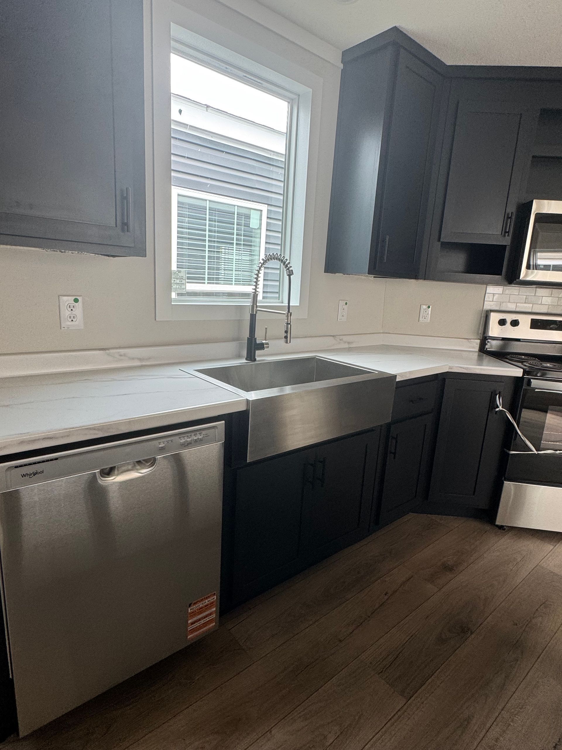 A kitchen with stainless steel appliances and black cabinets