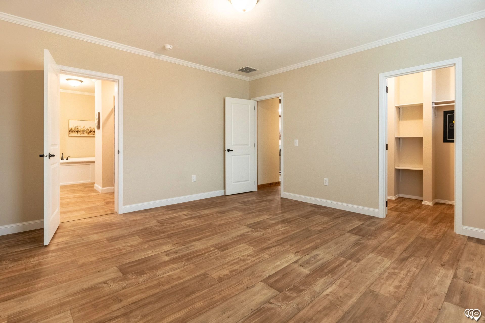 An empty bedroom with hardwood floors and a walk in closet.