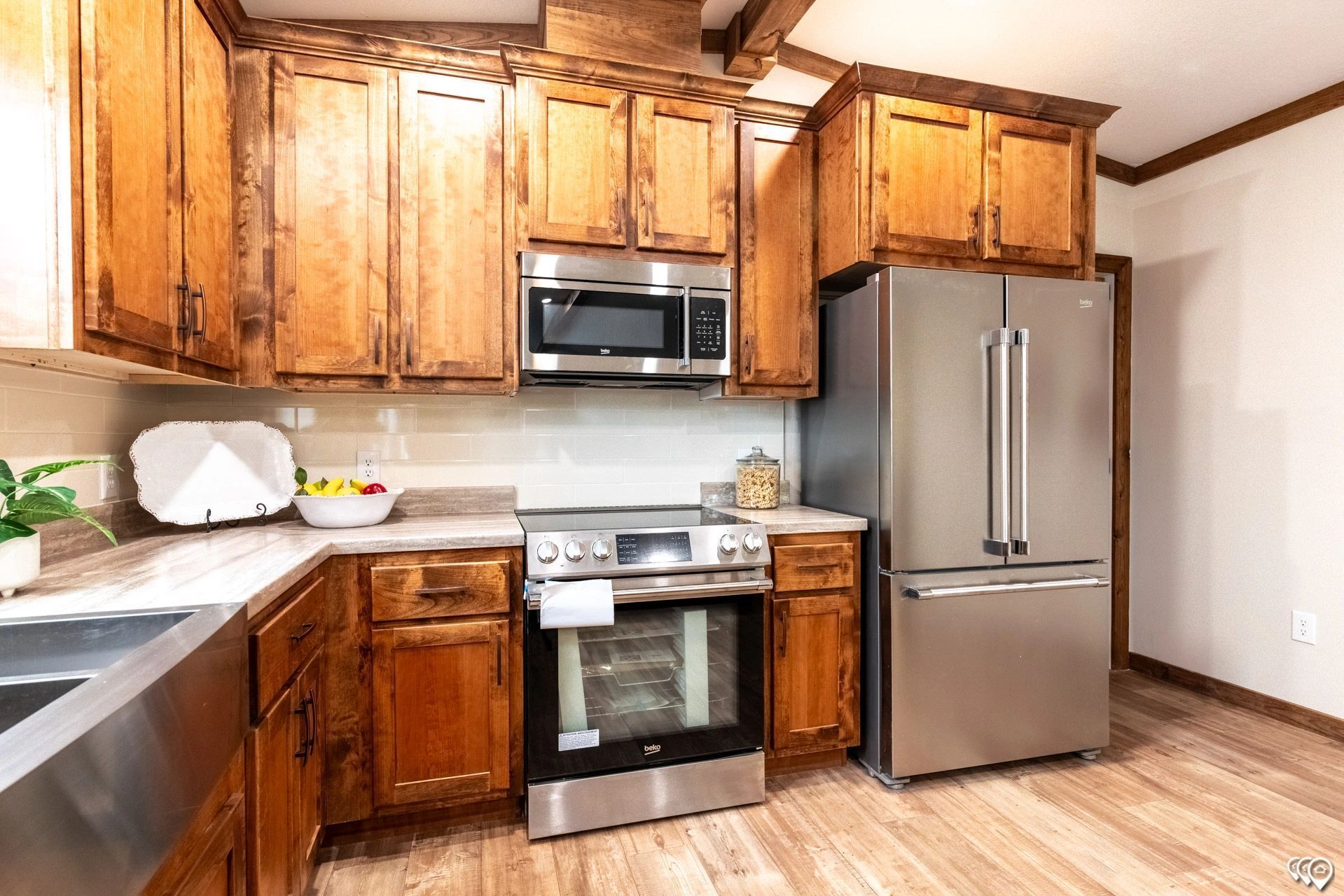 A kitchen with stainless steel appliances and wooden cabinets.