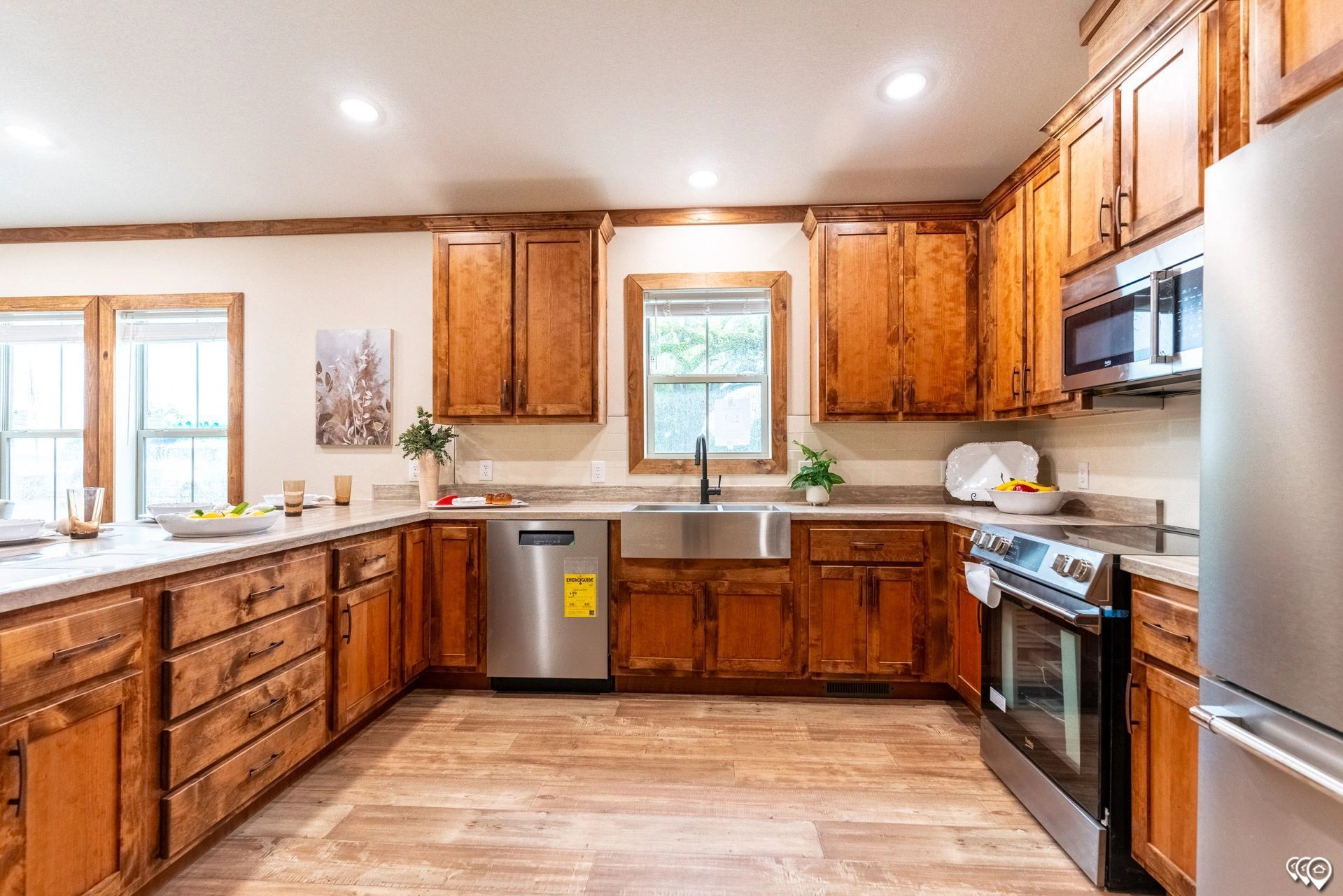 A kitchen with wooden cabinets , stainless steel appliances , and a sink.