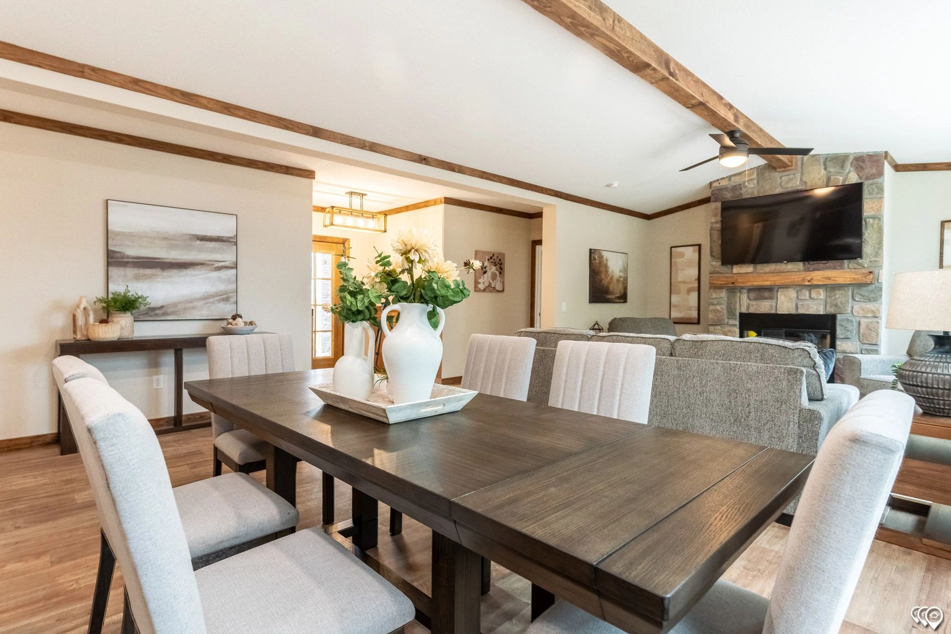 A dining room table and chairs in a living room with a fireplace.