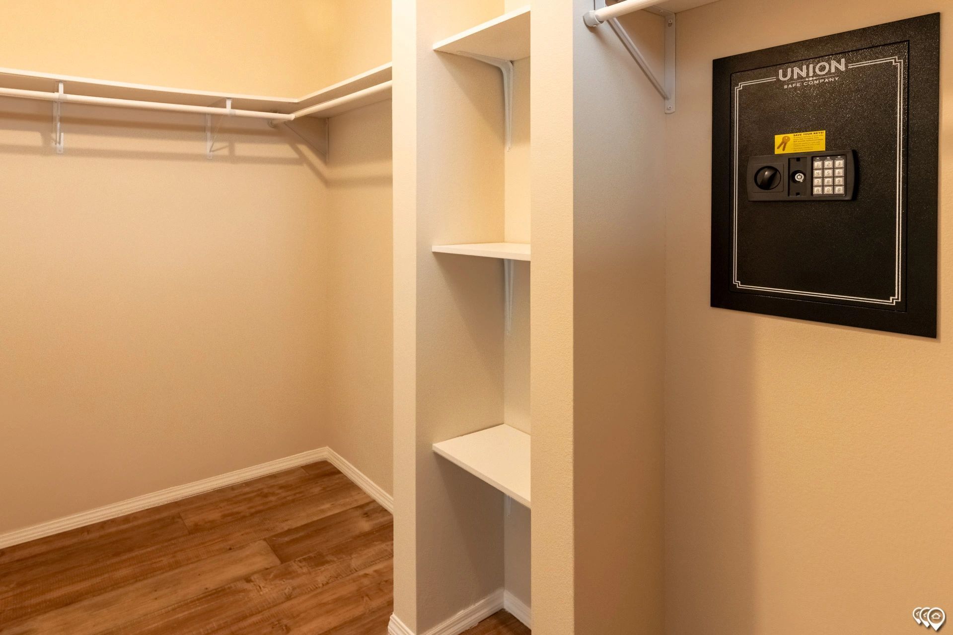 A walk in closet with shelves and a safe.