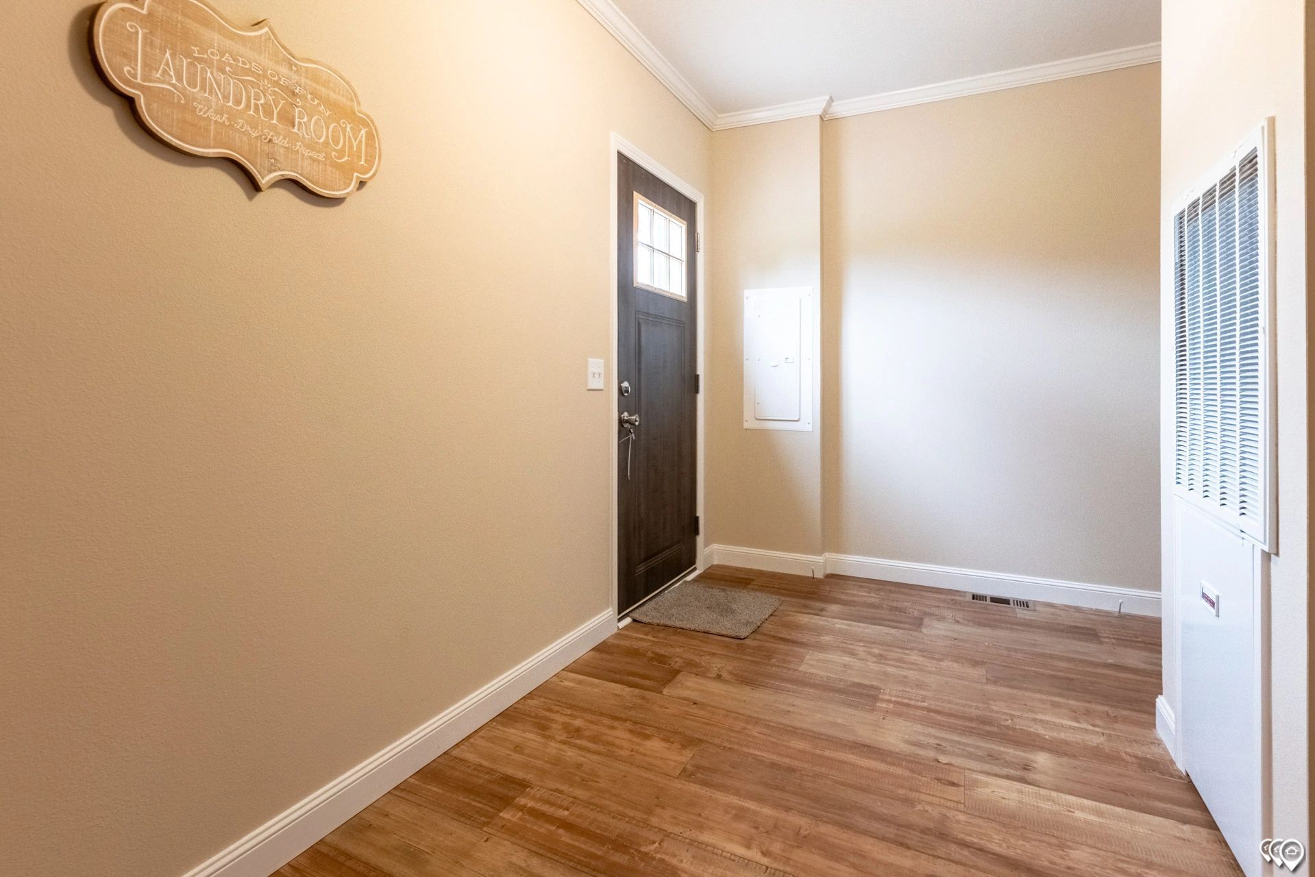 A hallway with hardwood floors and a door in a house.