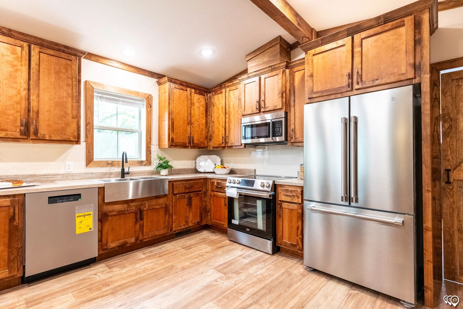 A kitchen with stainless steel appliances and wooden cabinets.