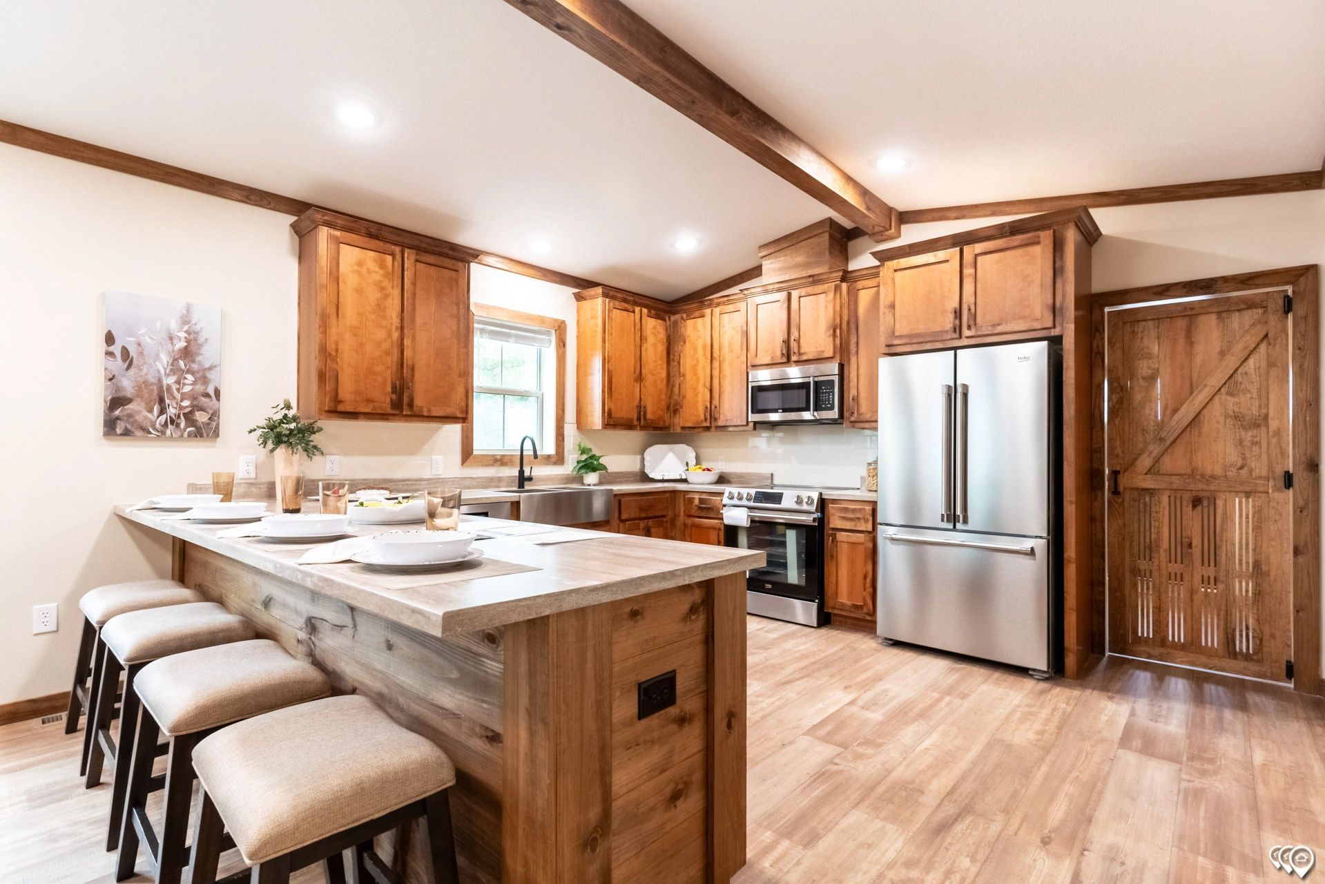 A kitchen with wooden cabinets , stainless steel appliances , and a large island.