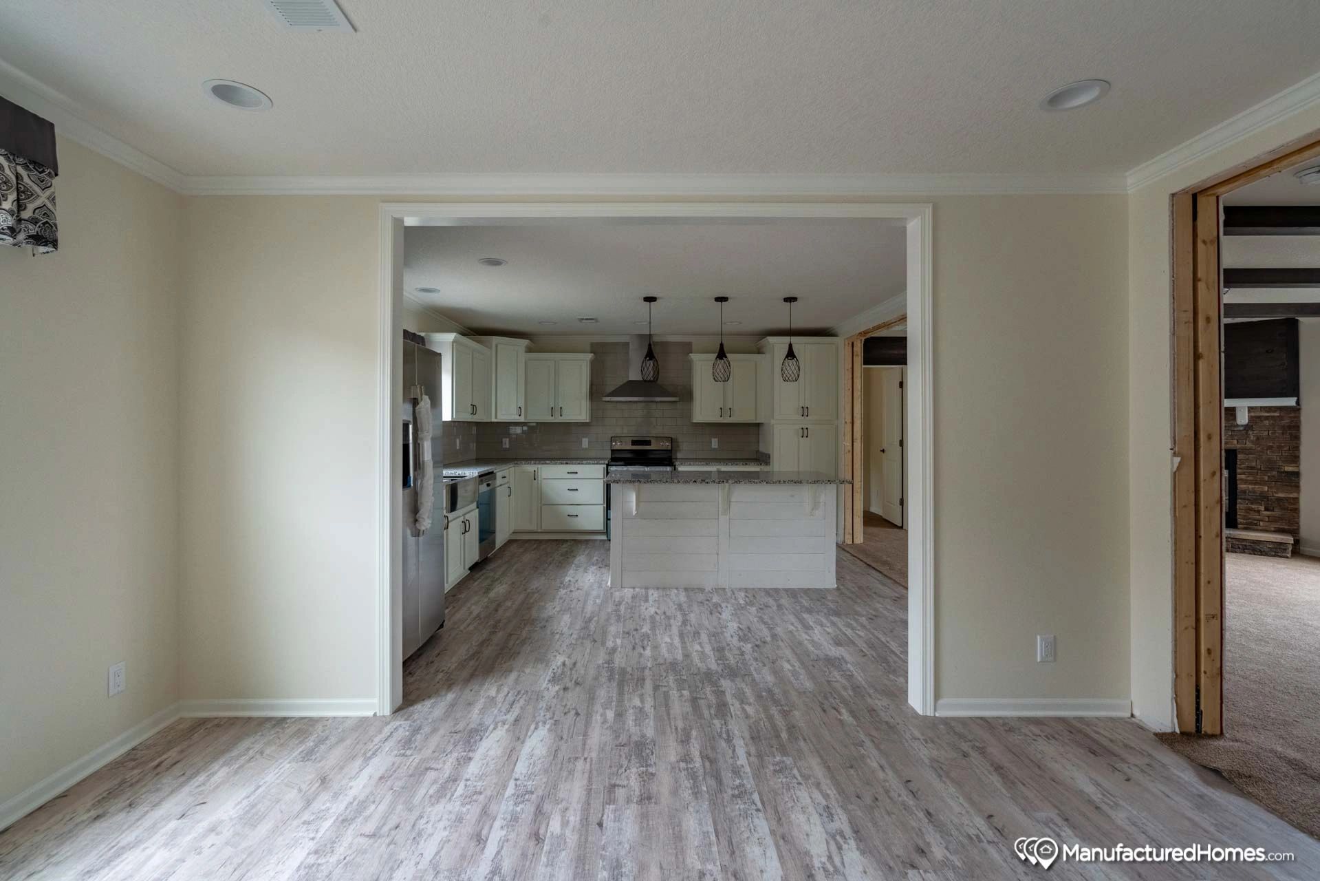 An empty room with a kitchen and a living room.