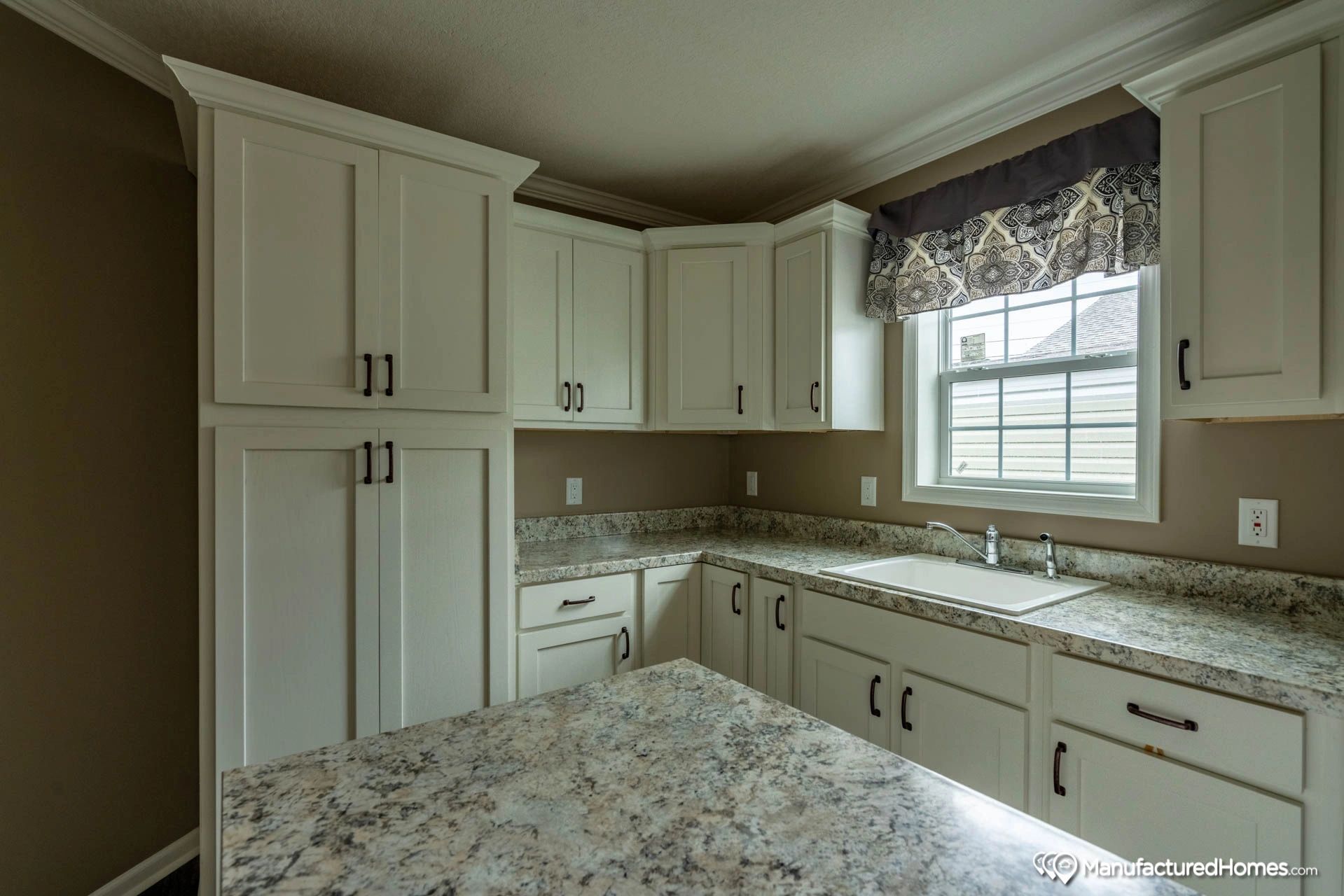 A kitchen with white cabinets and granite counter tops