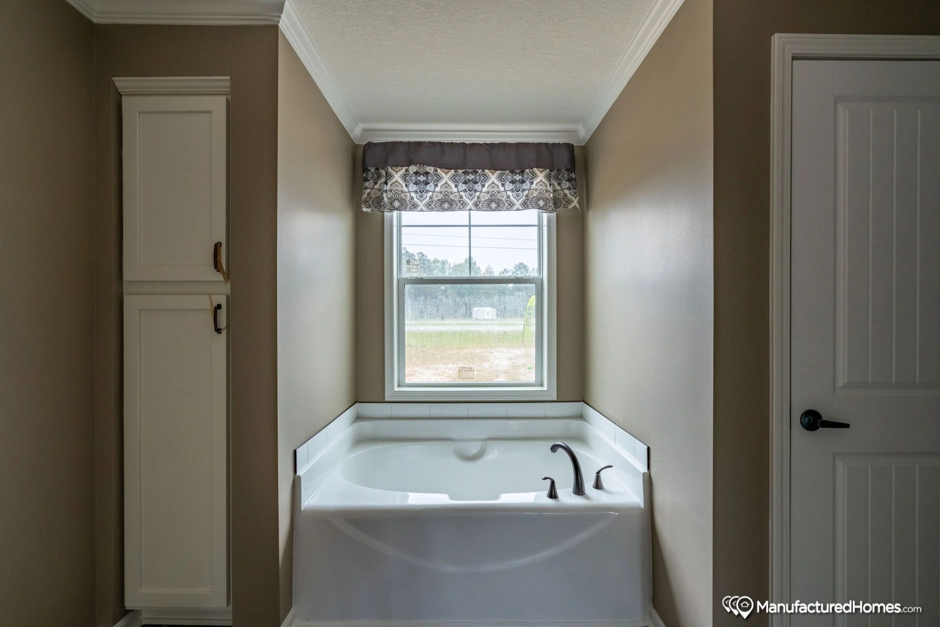 A bathroom with a large tub and a window.