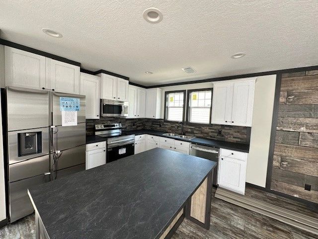A kitchen with stainless steel appliances and white cabinets