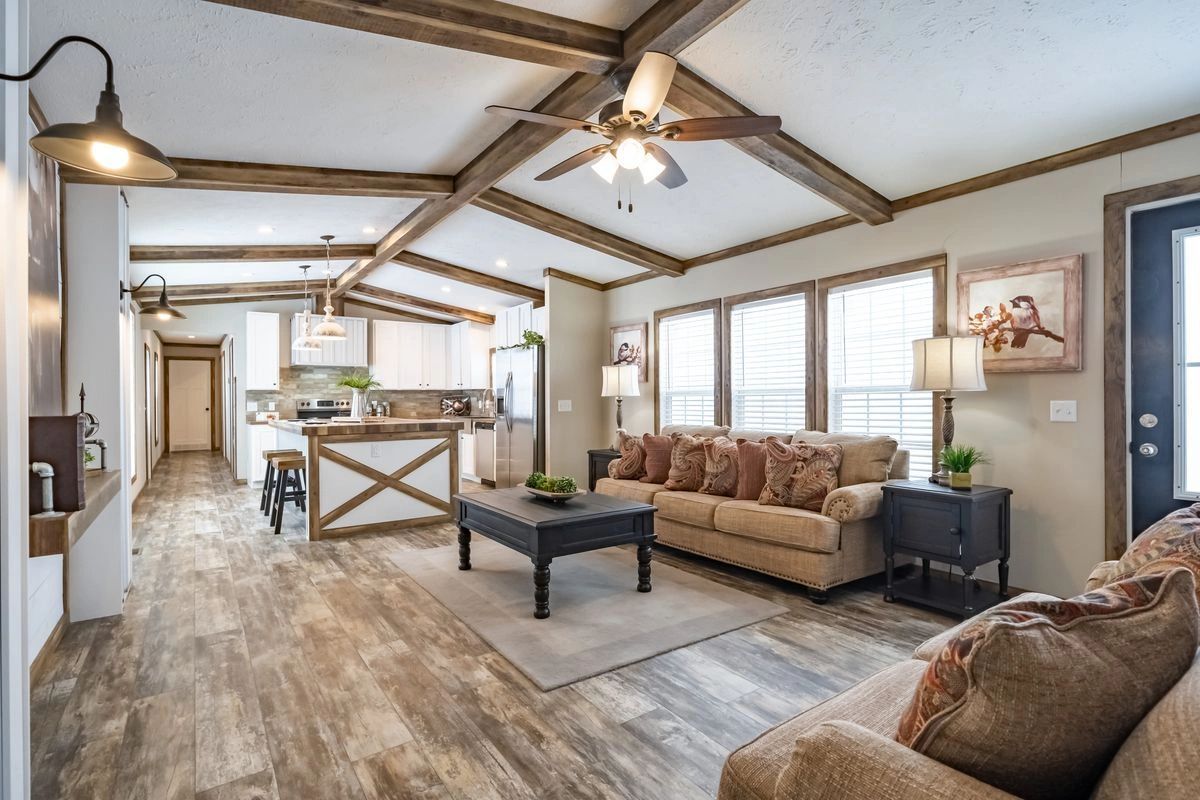 A living room with a couch , coffee table , and ceiling fan.