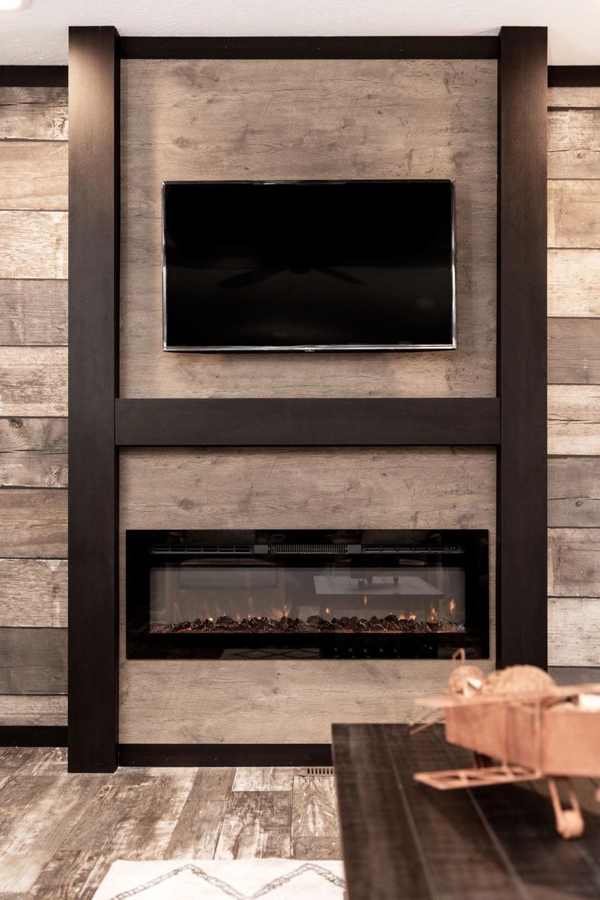 A living room with a fireplace and a flat screen tv on the wall.