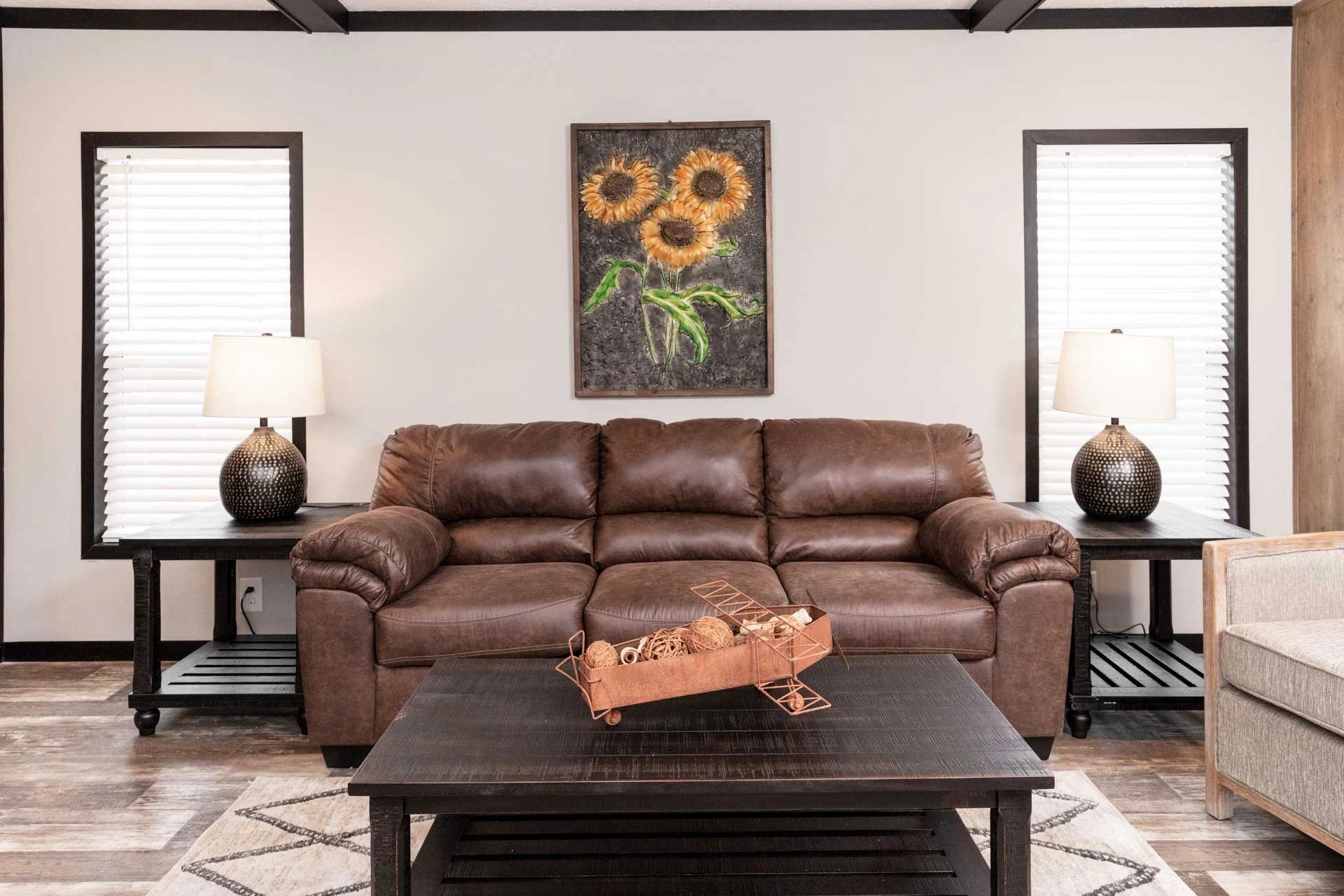 A living room with a brown couch and a coffee table.
