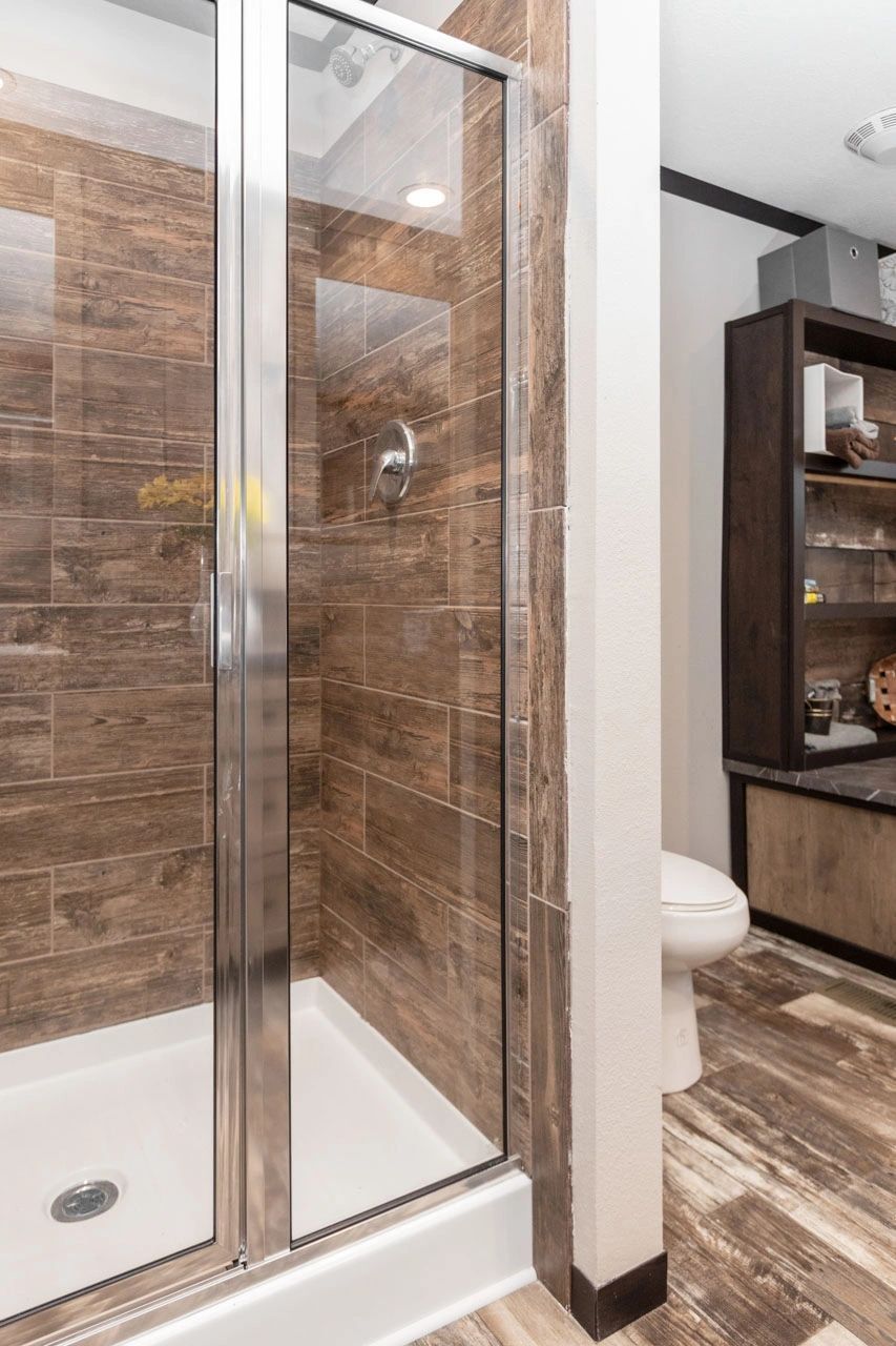 A bathroom with a walk in shower and a toilet.