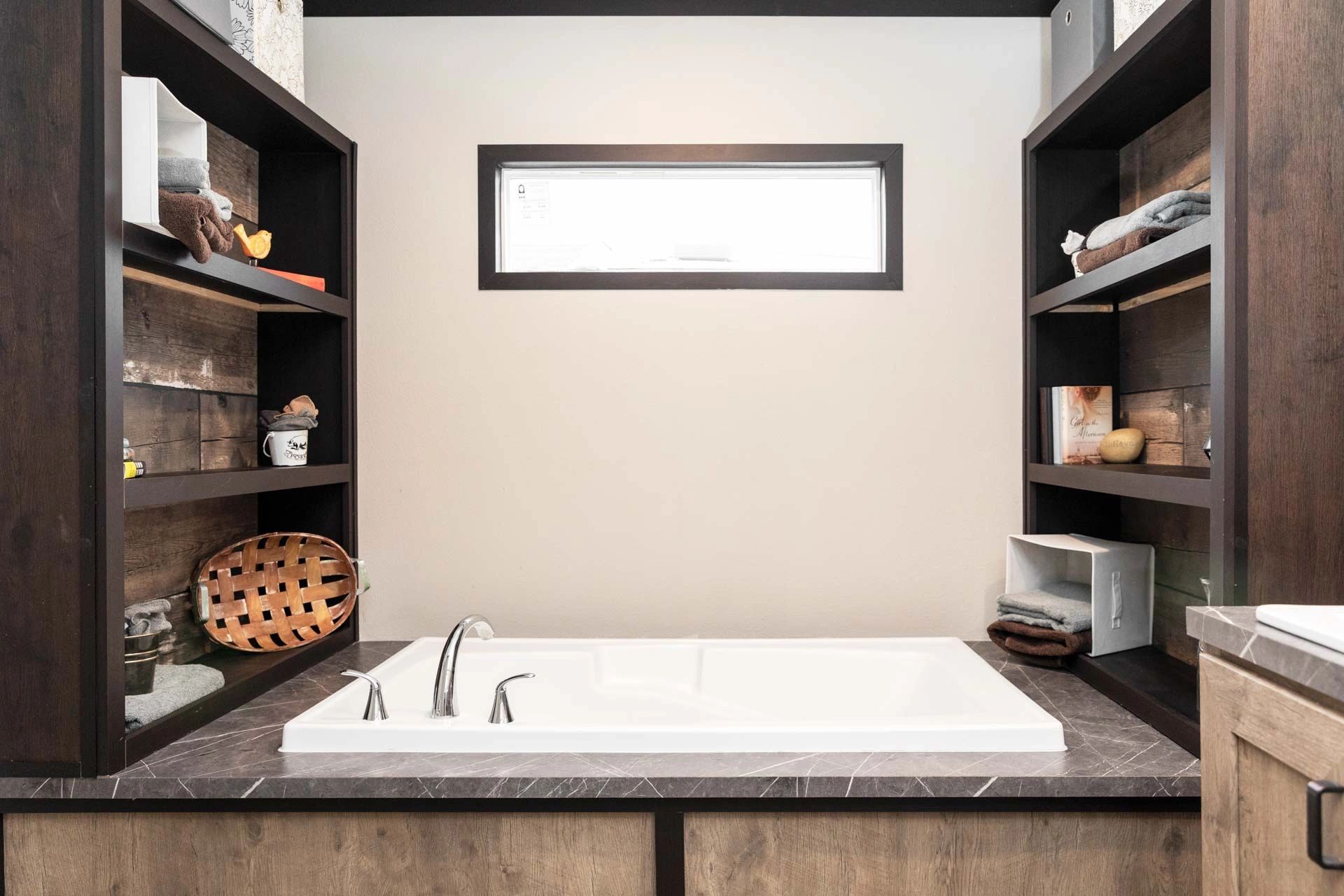 A bathroom with a large tub and shelves.