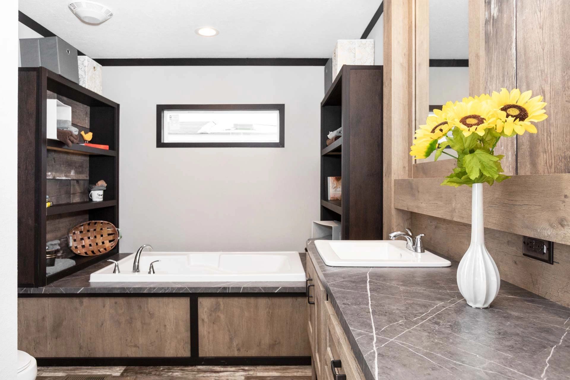 A bathroom with a tub , sink and mirror.