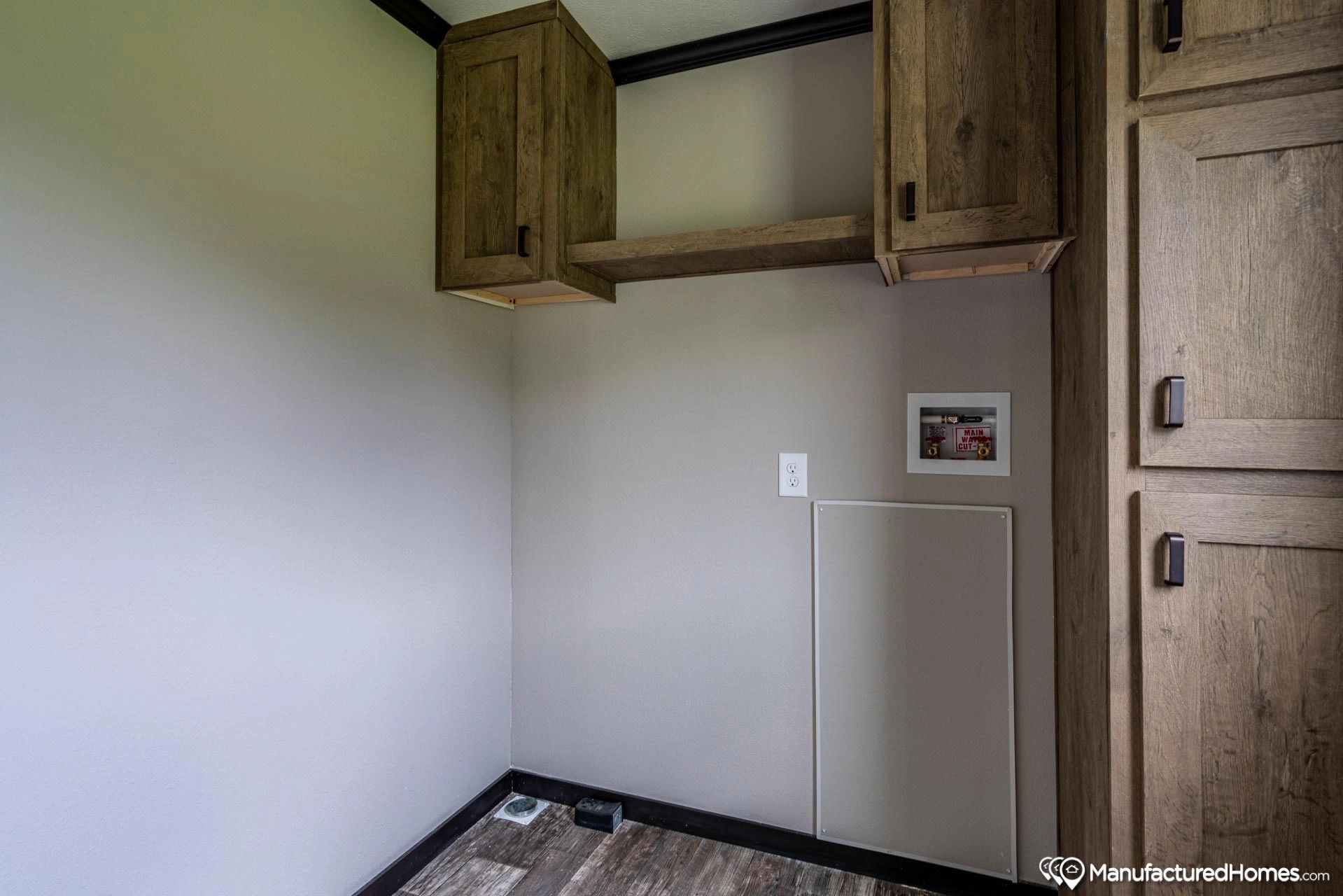 A laundry room with wooden cabinets and a washer and dryer.
